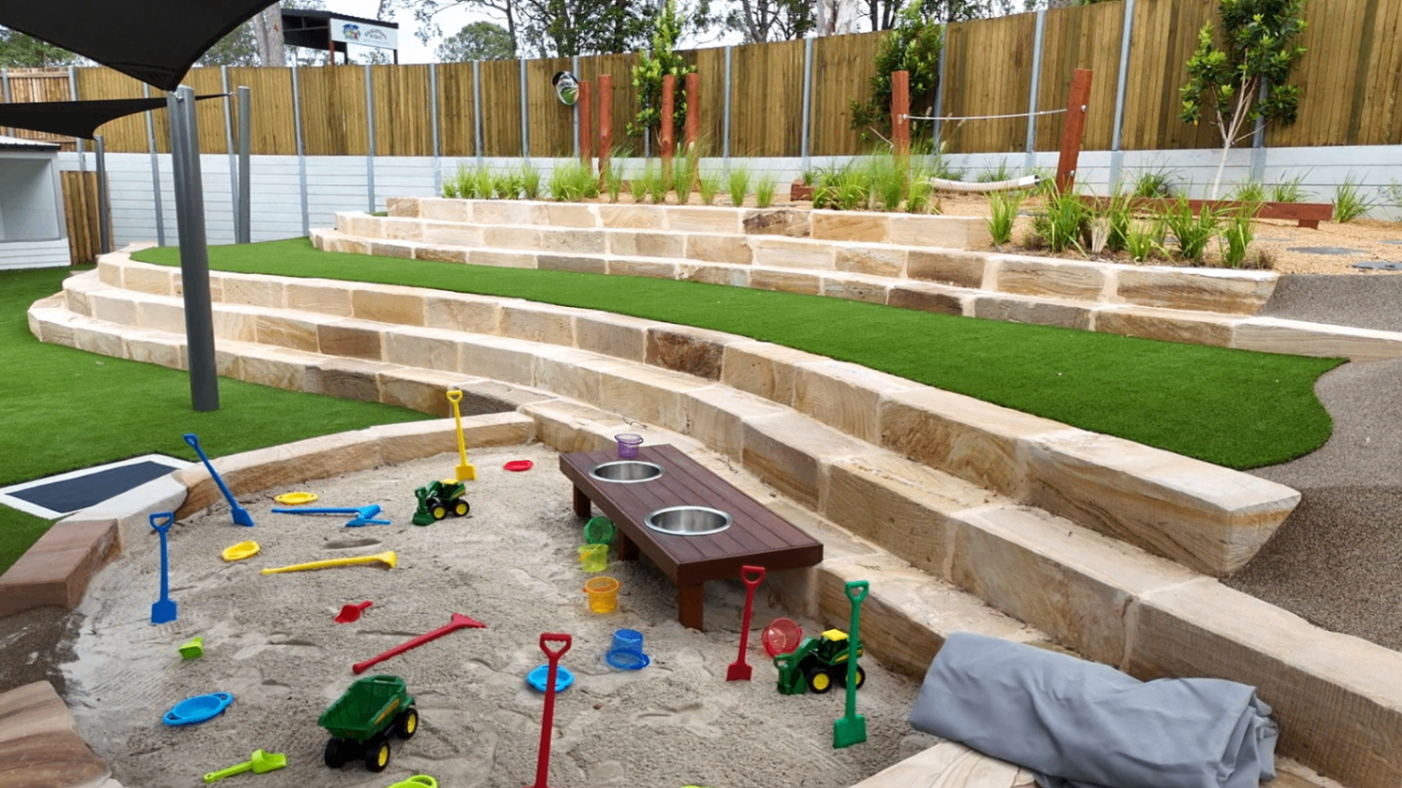 Sandpit and tiered sandstone amphitheatre in the Greenbank Covella outdoor area
